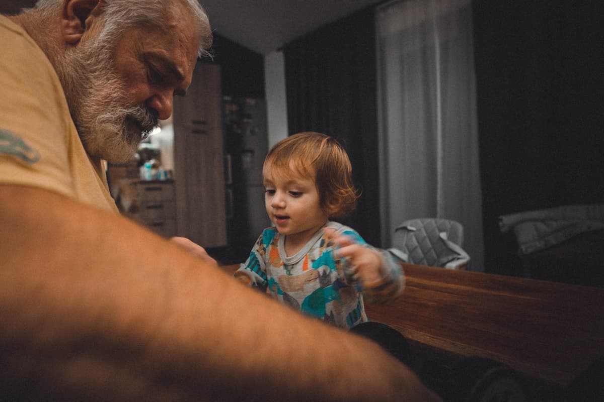 An elderly man and young child sharing a quiet moment at a table