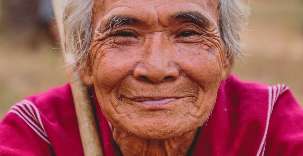 An elderly person with a warm, weathered smile