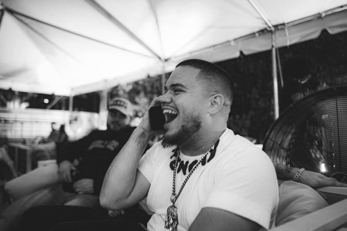 A man laughing mid-conversation on a phone call