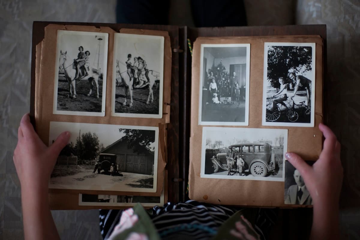Someone opening a vintage family photo album, browsing through memories